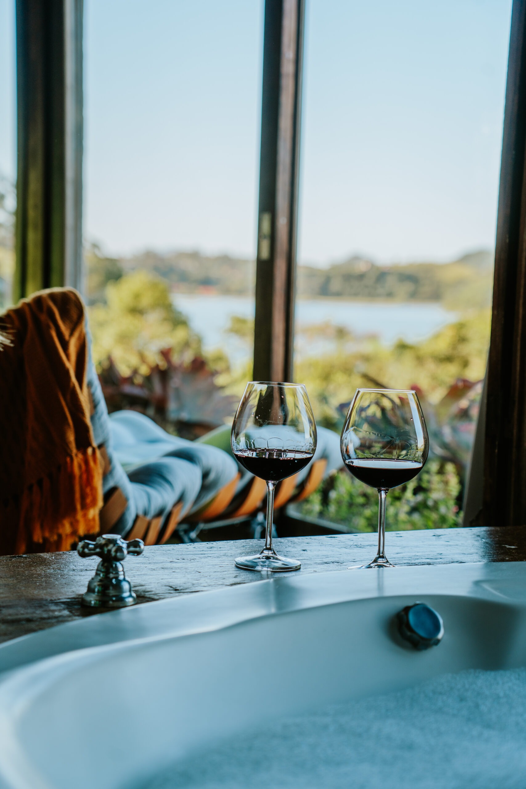 Taças de vinho na borda da banheira com vista