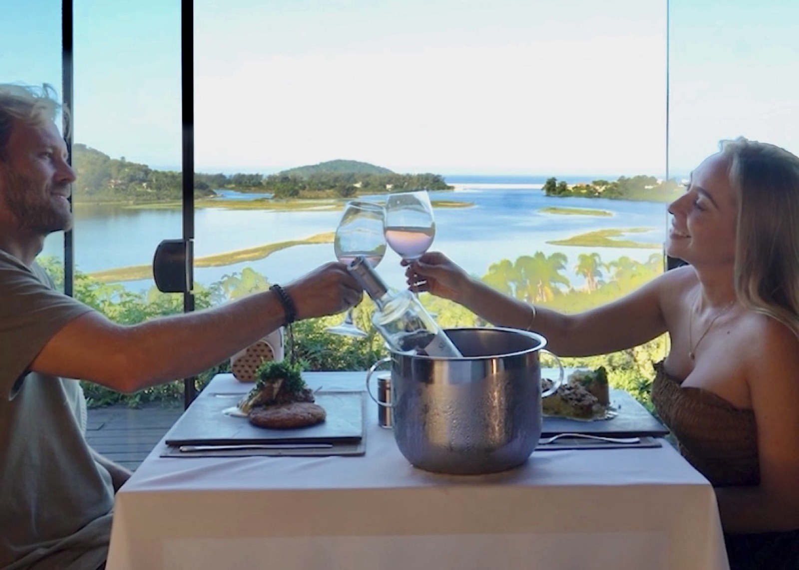 Casal brindando no Bistrô da Piteira com vista para a Lagoa de Ibiraquera