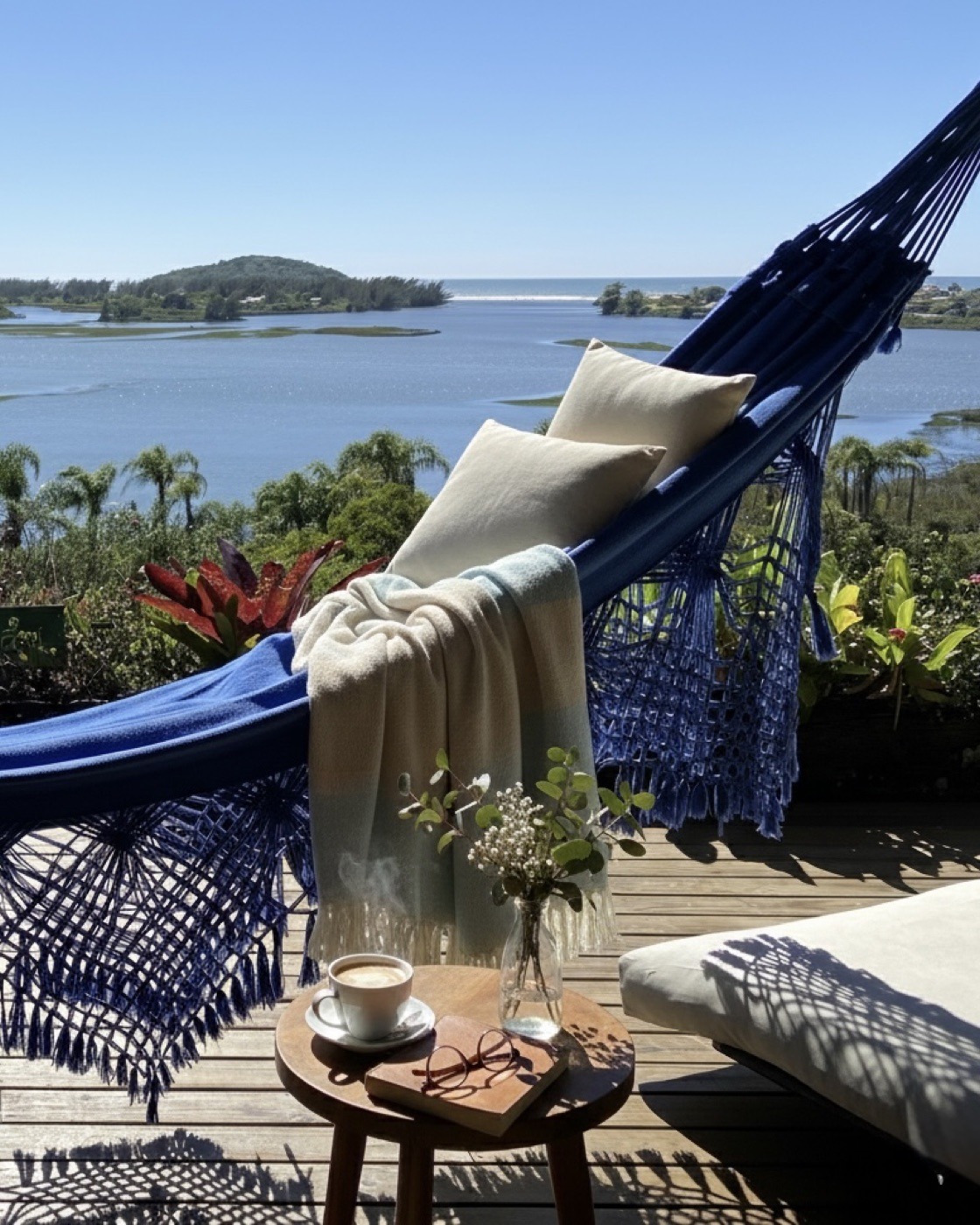 Rede azul na varanda com vista para a lagoa